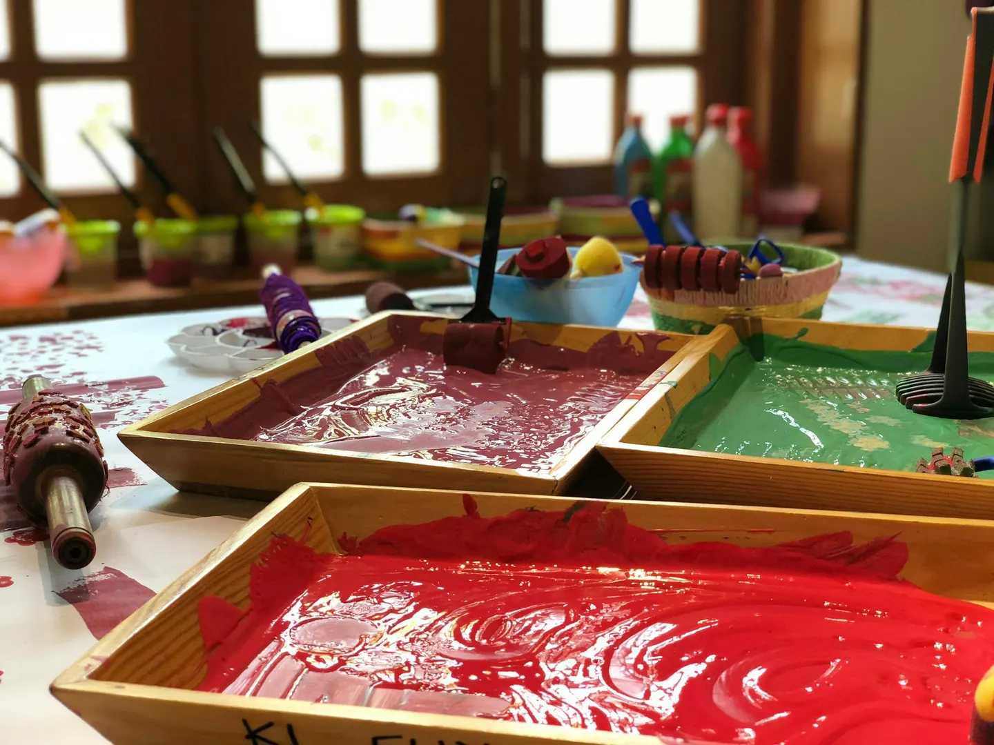 Bandejas de pintura y rodillos preparados para una actividad plástica
